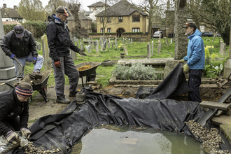 Volunteers creating a pond in a local churchyard 