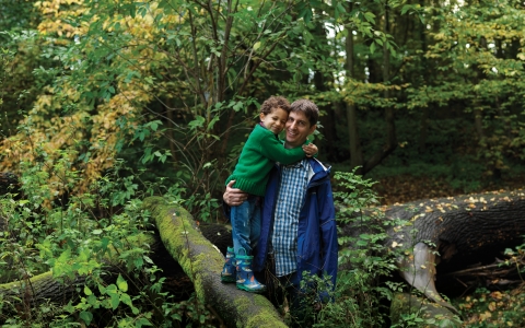 Father and son standing on a tree branch