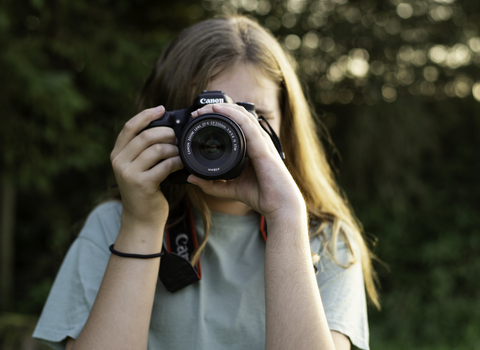 A girl taking photograph with an SLR camera